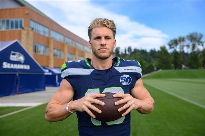 Seattle Seahawks football posing with a football in hands