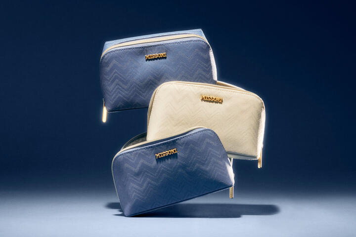 Three Delta x Missoni amenity kits are stacked on top of eachother.