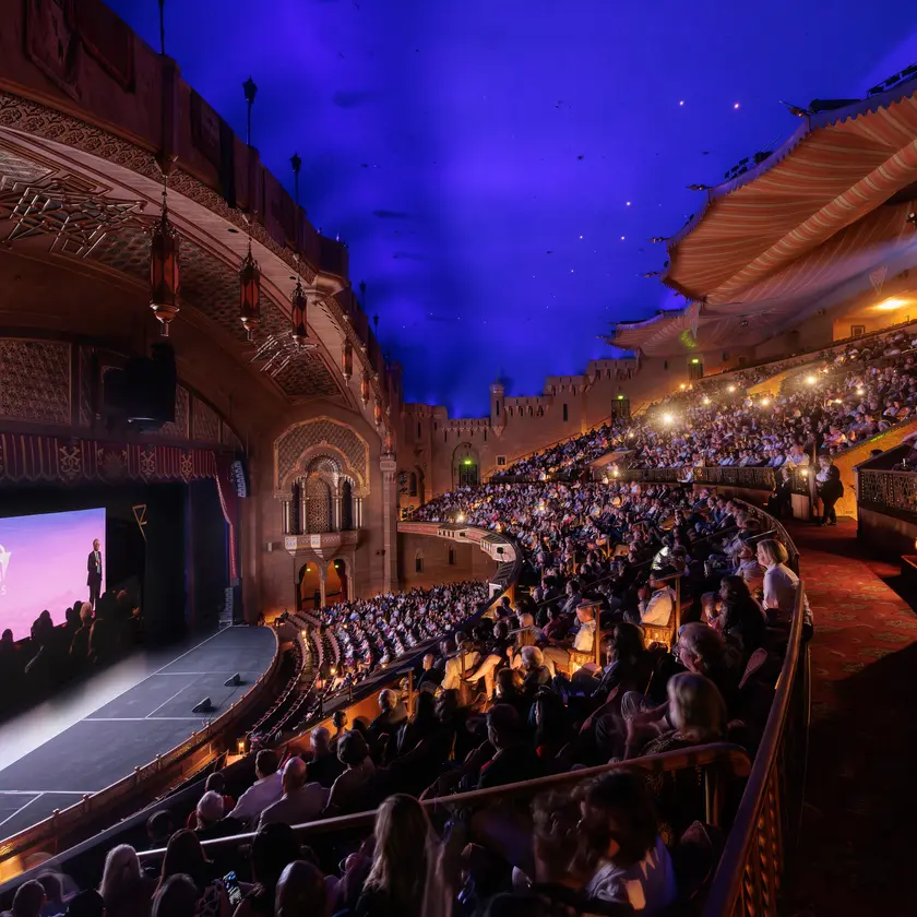 Interior view of the Fox Theatre, with guests seated and watching the film during the premiere event.