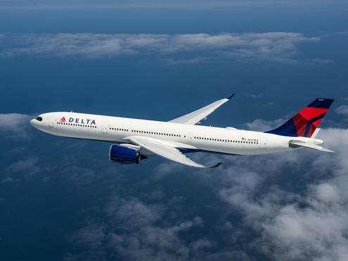 An A330-900 flying among clouds