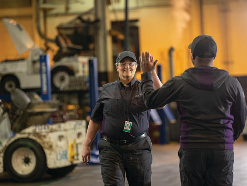 Delta employees high-five at work.