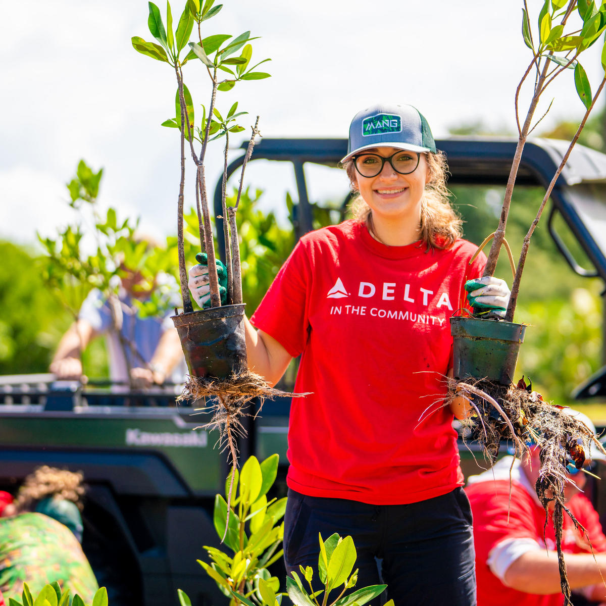 A Delta volunteer holds mangroves.