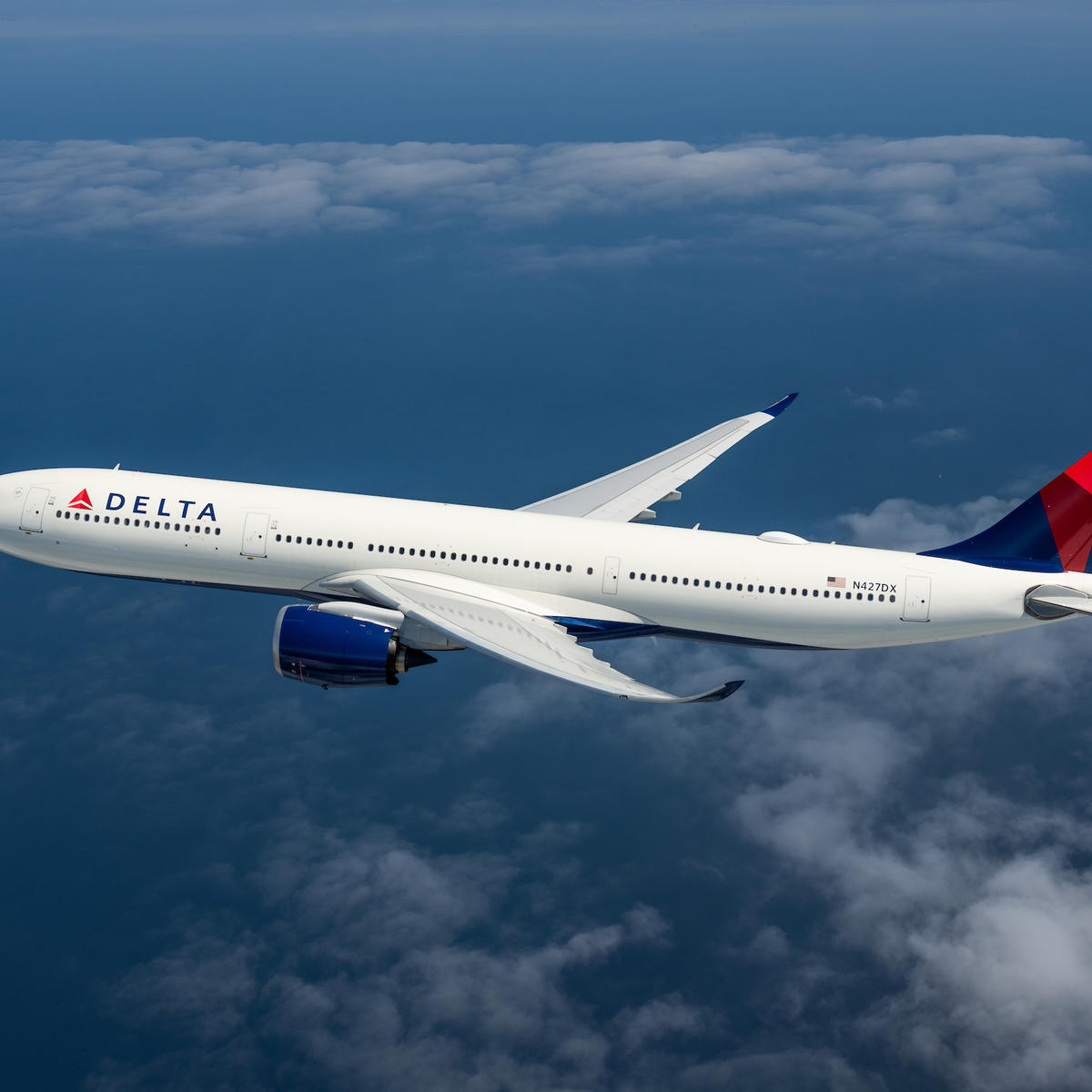 An A330-900 flying among clouds