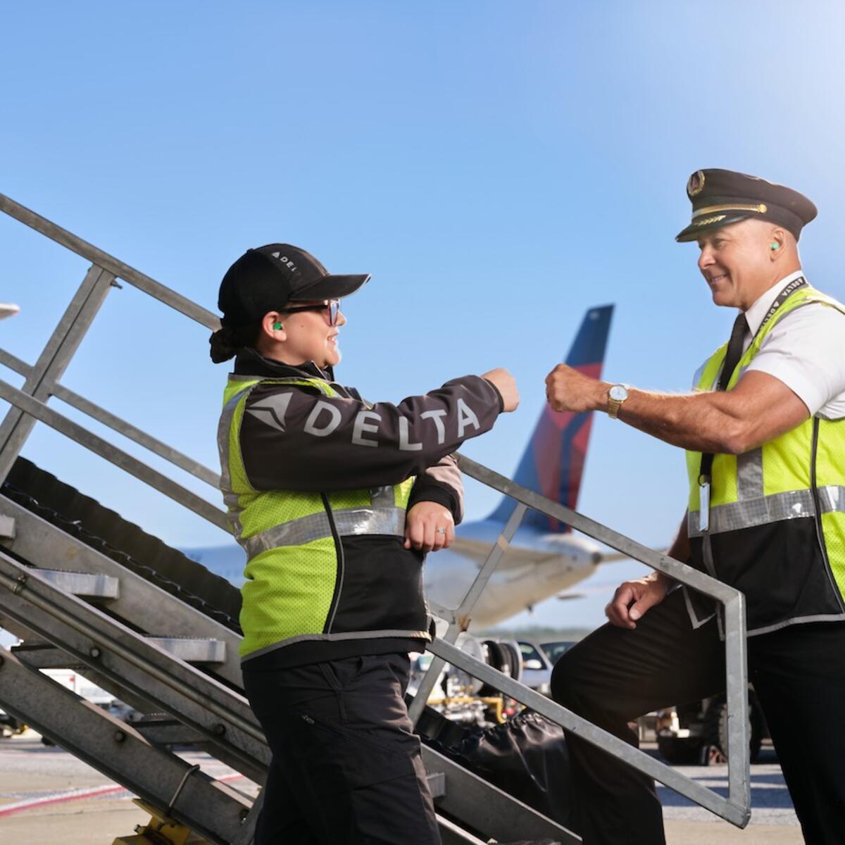 Delta pilot and ground agent giving fist bump on the ramp