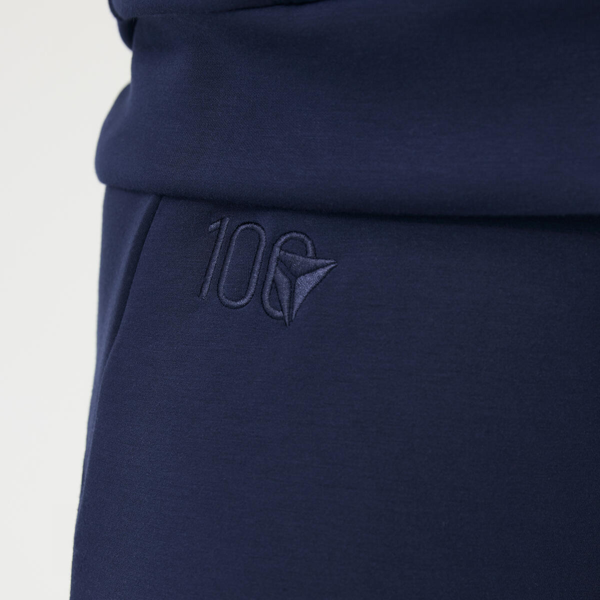 Close up of Delta Centennial logo embroidered on navy wide leg Spanx pants.