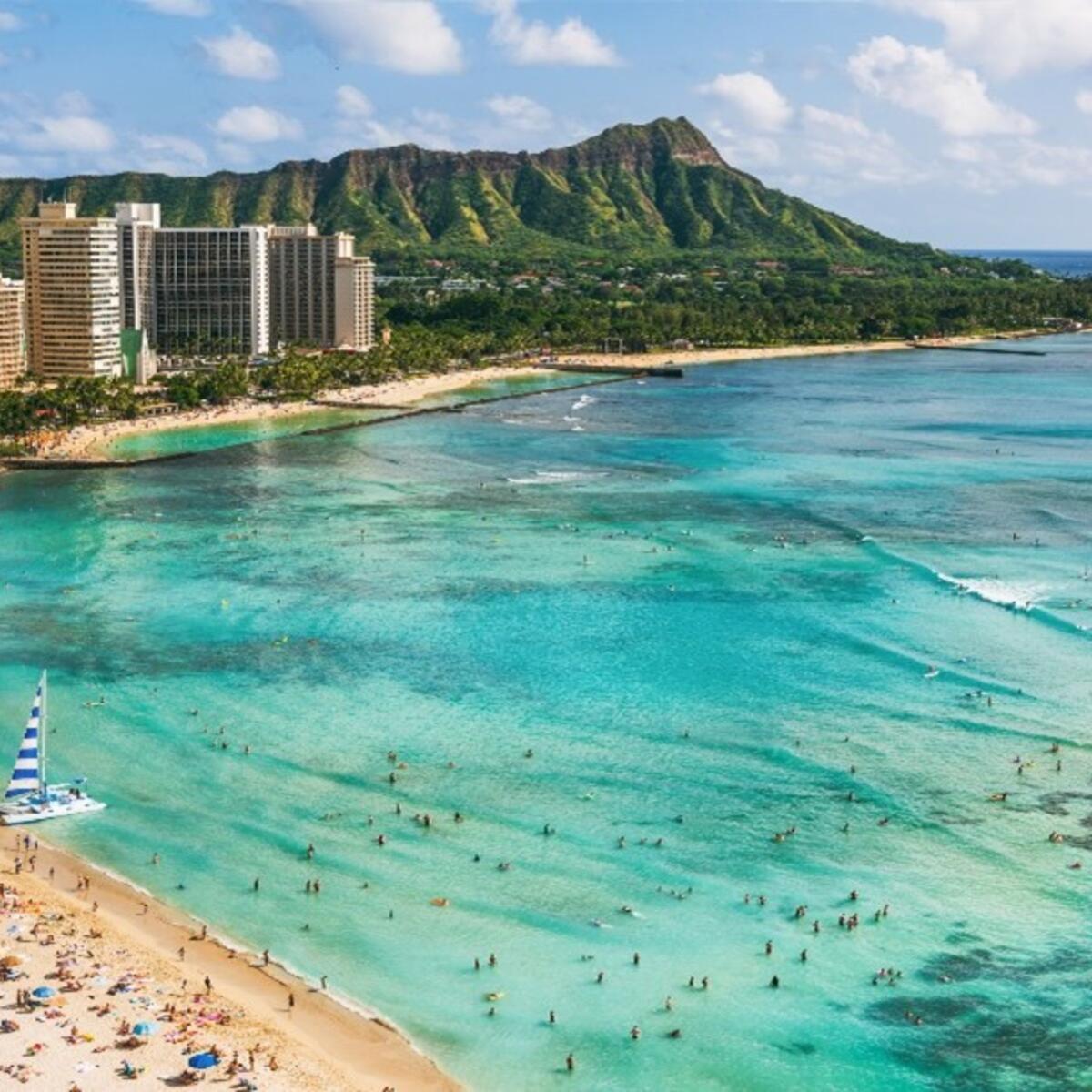 A skyline overlooking a beach and turquoise waters in Hawaii.