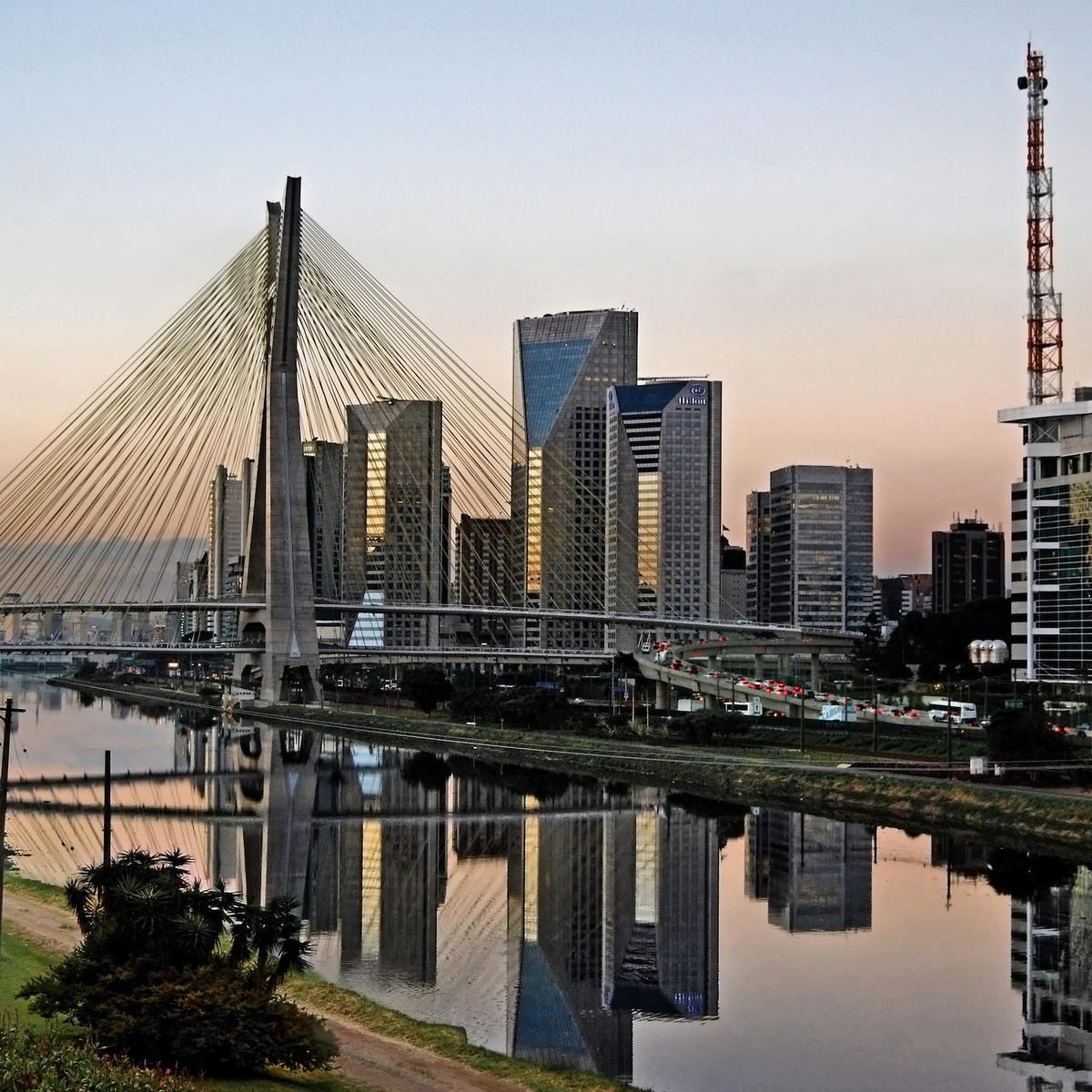 Sao Paulo landmark at dusk. Octavio Frias de Oliveira Stayed Bridge and modern buildings and districts of the skyline.