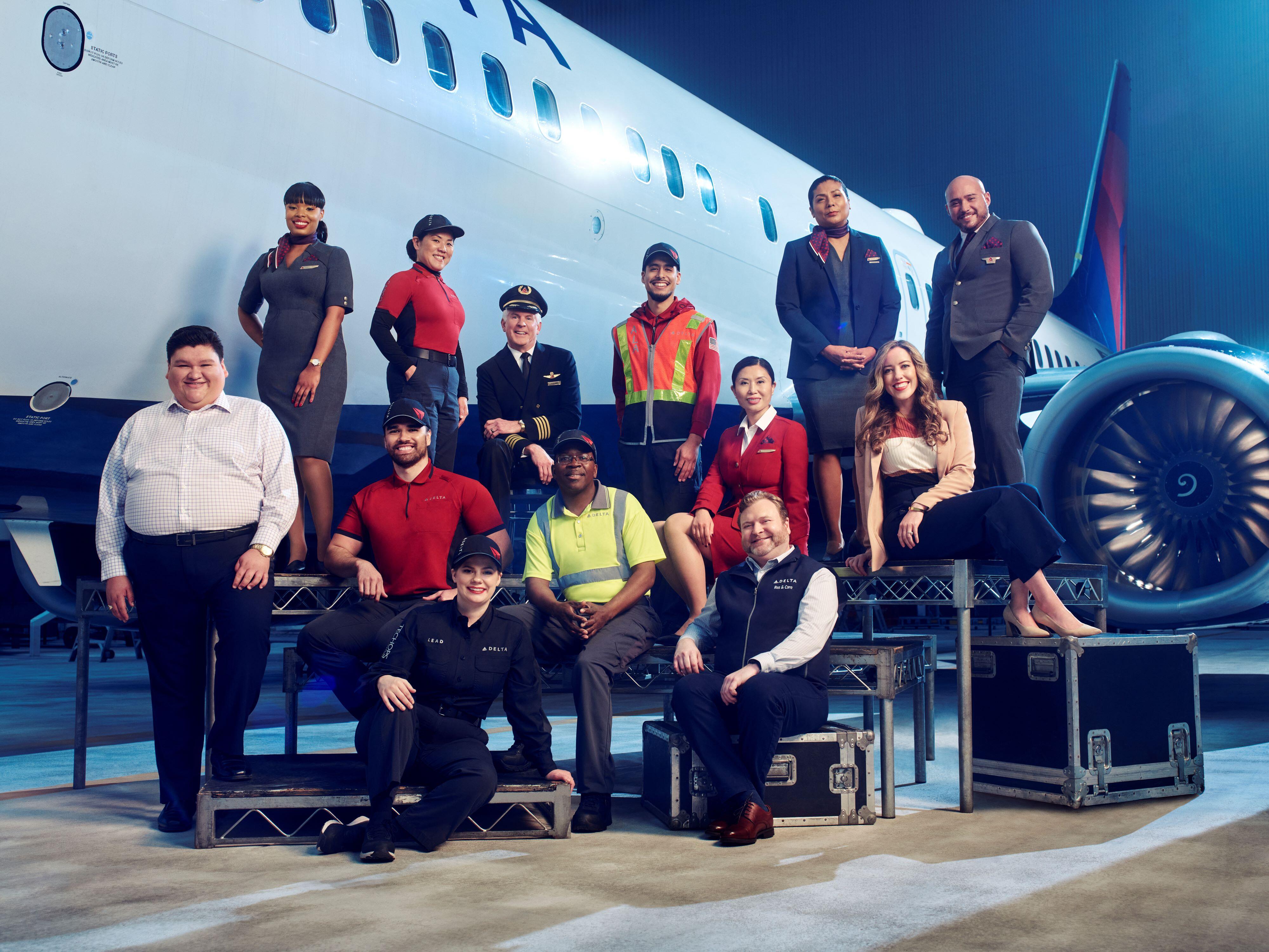 Employees from across Delta's divisions pose in front of a plane in 2023.