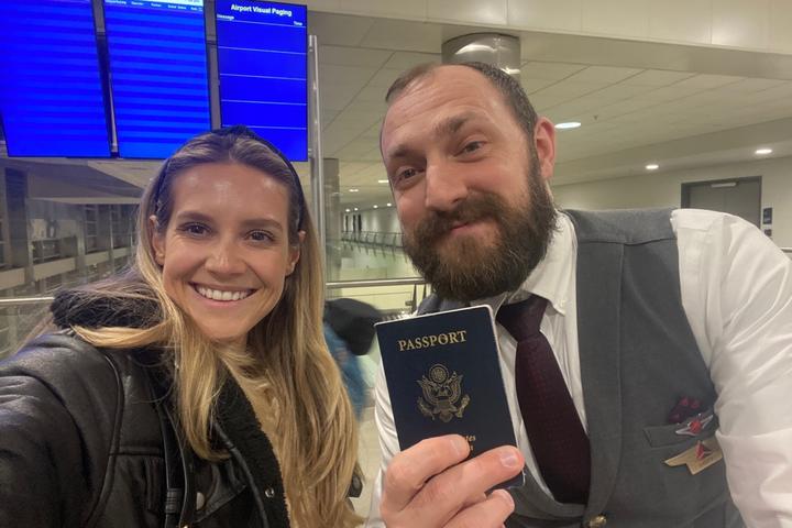 Lawryn Fellwock poses with Delta flight attendant Dusty Dills -- holding the passport she left behind on her honeymoon trip.