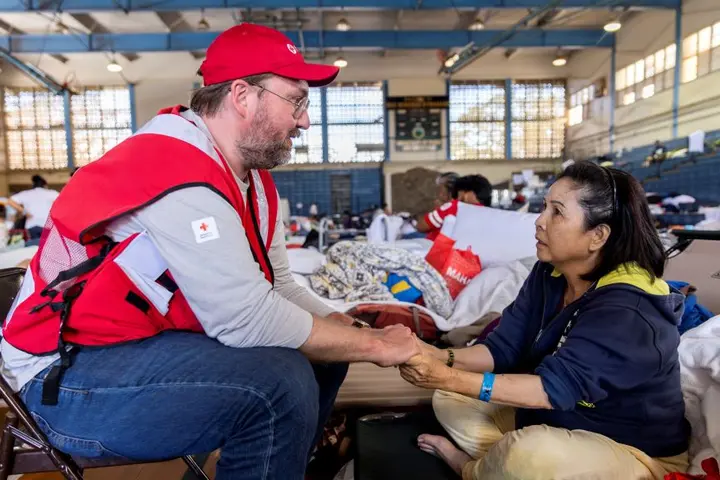 American Red Cross staffer Doyle Rader holds hands with Thao Tran