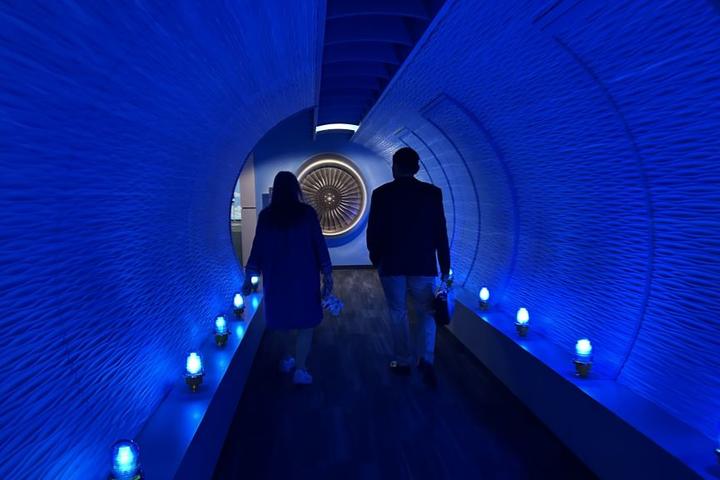 Todd O., Delta's most frequent flyer, and a Flight Museum employee walk through the breezeway before touring the Boeing 767 Spirit of Delta on the other side. 