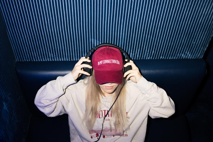 A SkyMiles member enjoys the Delta Sync Space at Delta's SXSW lounge while wearing exclusive Delta x SXSW merch.&nbsp;