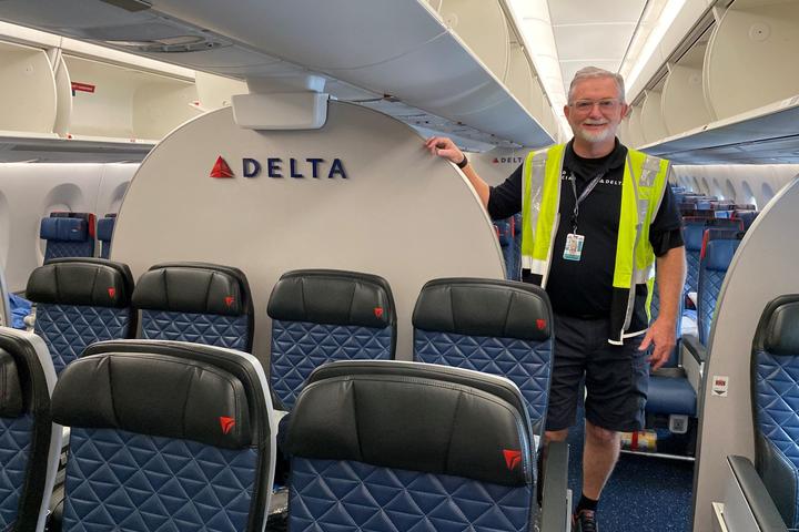 Tracy Rawls, Lead Aviation Maintenance Technician on the Delta TechOps Cabin Maintenance Team, stands on board an airplane.