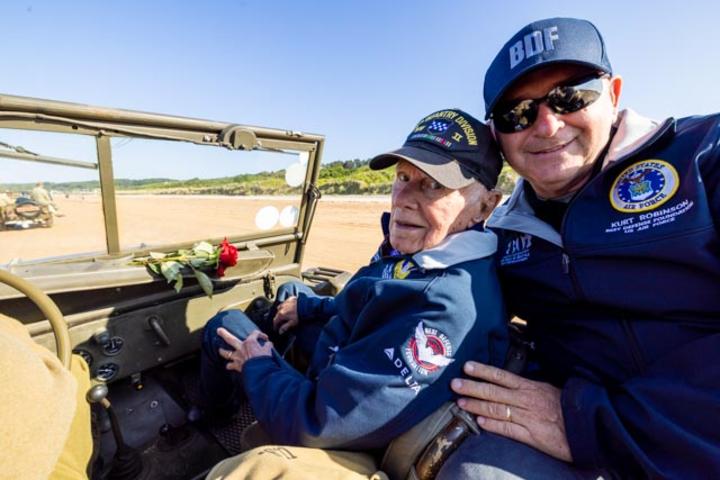 After signing countless autographs, the veterans enjoyed a ride on World War II-era vehicles to Omaha Beach, where they laid roses to remember comrades who lost their lives on those shores.