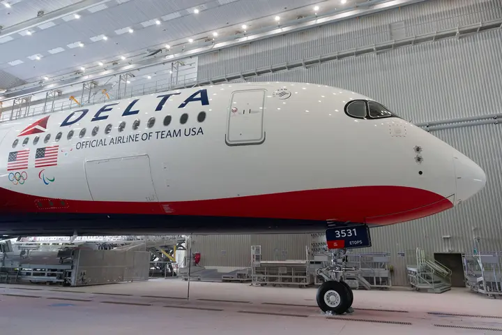 Front end of Delta plane with Team USA livery, parked in hangar.