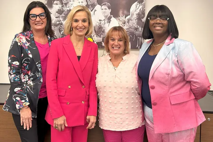 EVP and Chief People Officer Allison Ausband posing with three Delta employee breast cancer survivors.