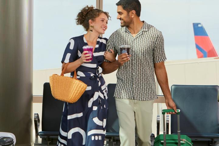 Couple in airport enjoying Starbucks beverages