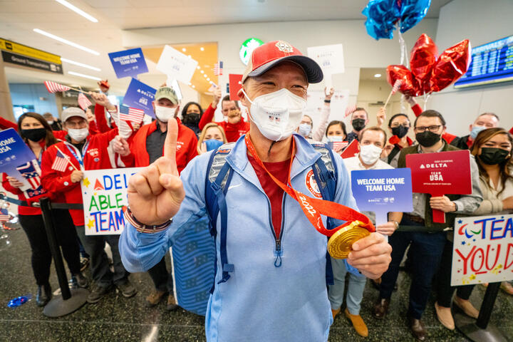 Jen Lee shows his gold medal after returning from the Paralympic Games.