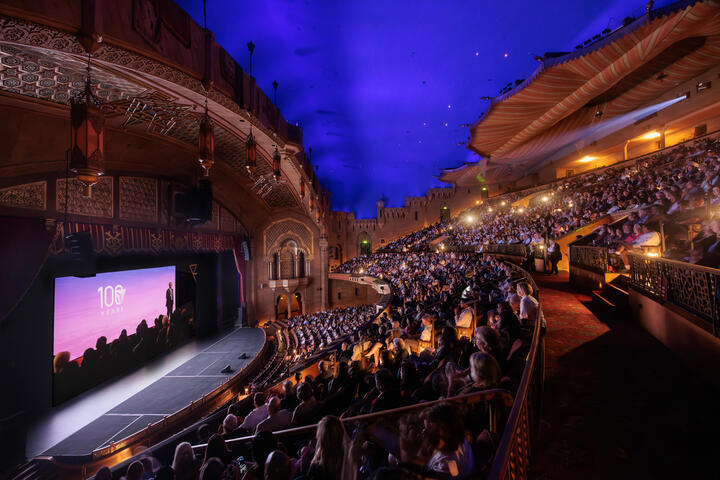 Interior view of the Fox Theatre, with guests seated and watching the film during the premiere event.