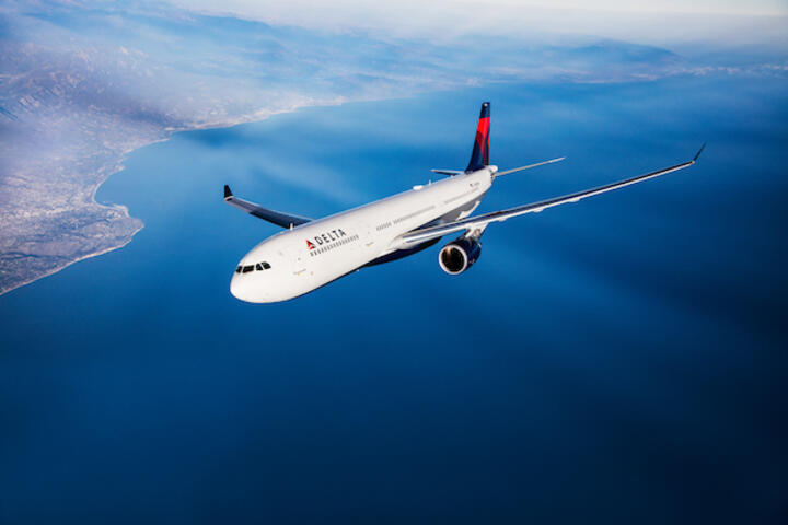 A Delta branded A330 flies in the sky. 