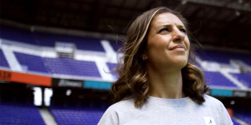 Close up of soccer legend Carli Lloyd standing in a soccer stadium