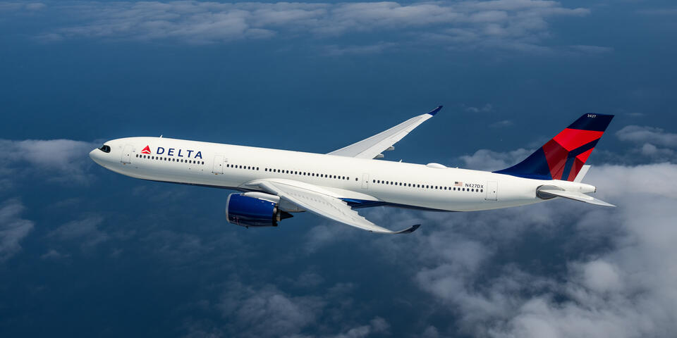An A330-900 flying among clouds