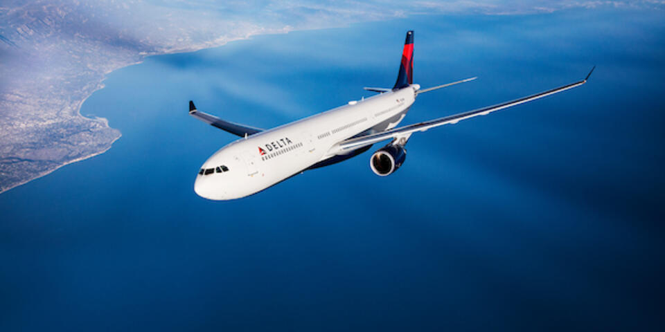 A Delta branded A330 flies in the sky. 