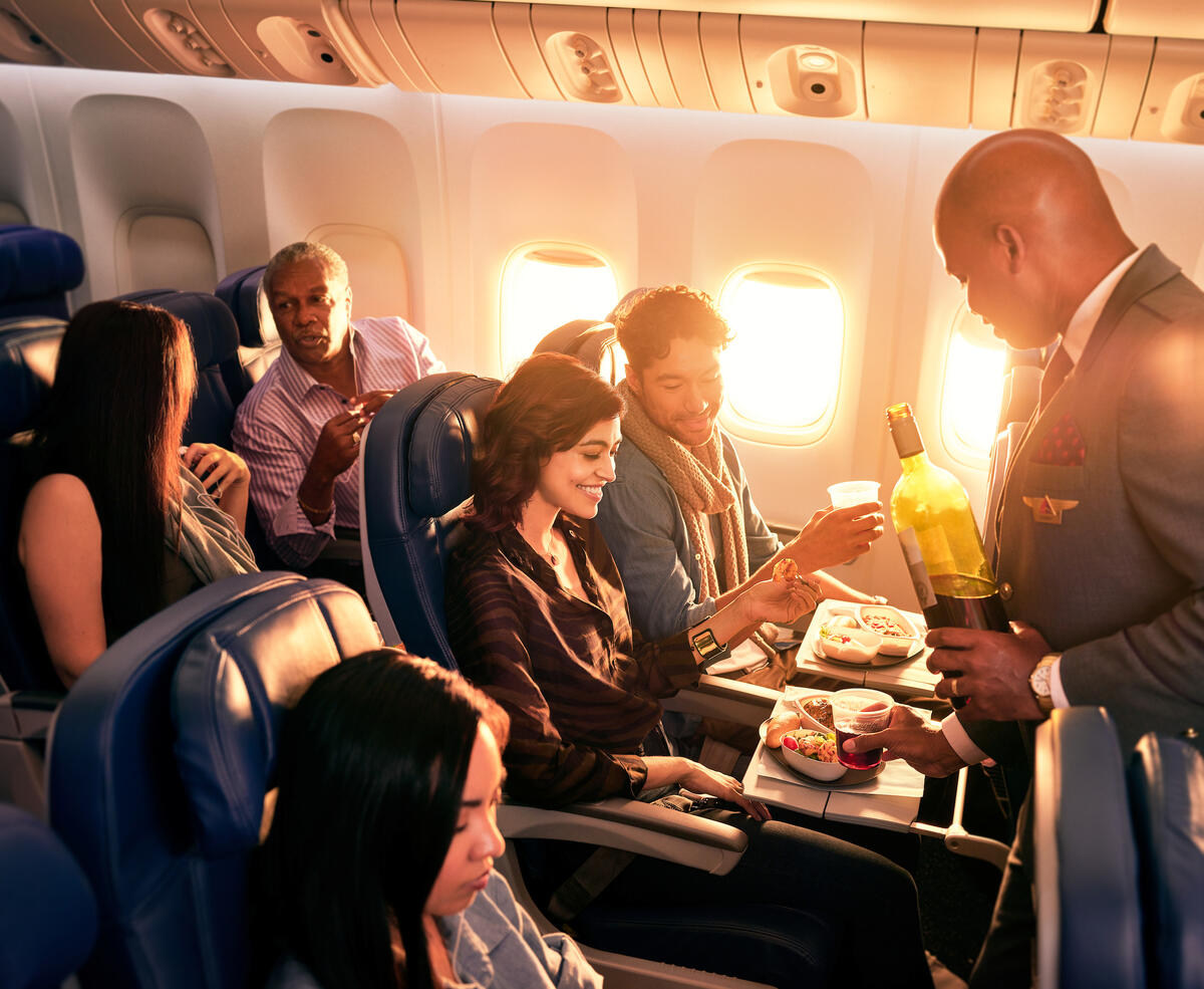 Delta flight attendant with Main Cabin customers.