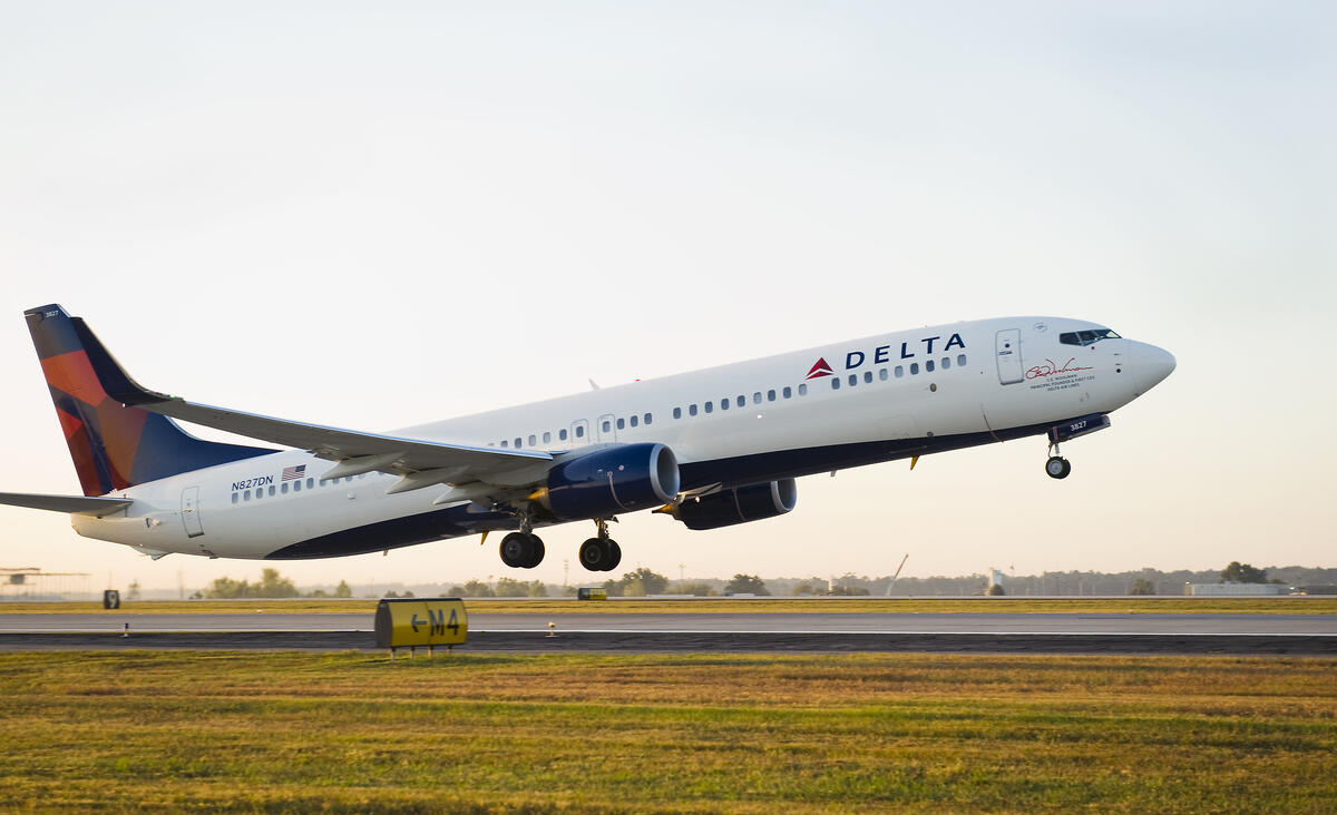 A 737-900 takes off into a clear sky.