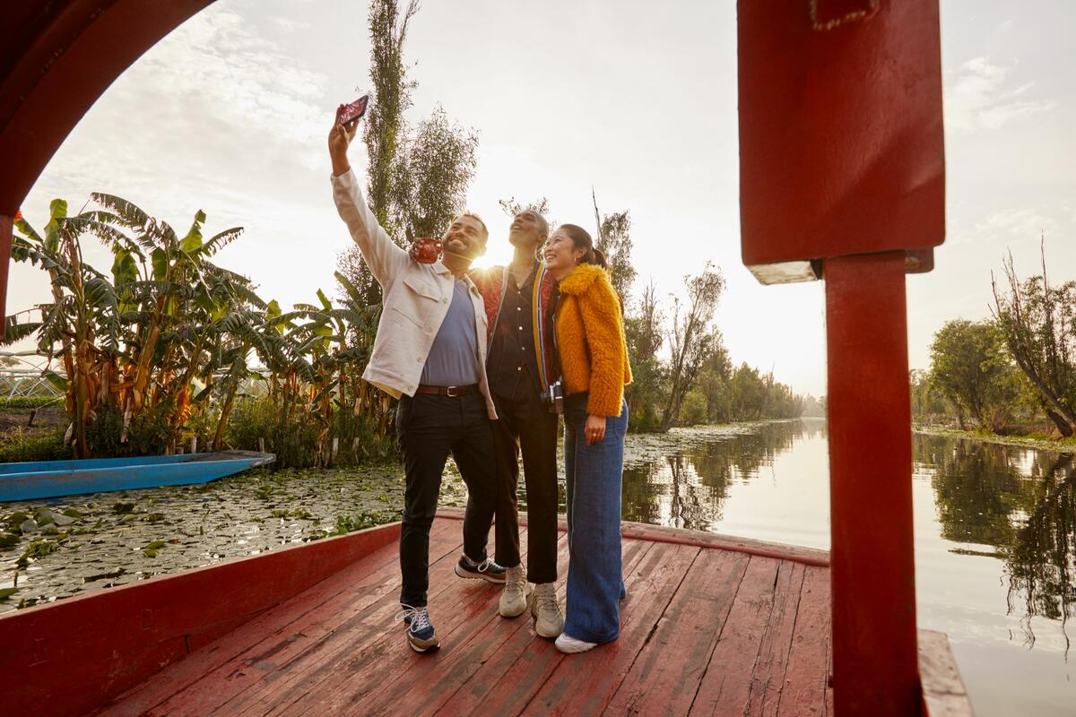 Three people take a selfie on a Mexican trajinera.