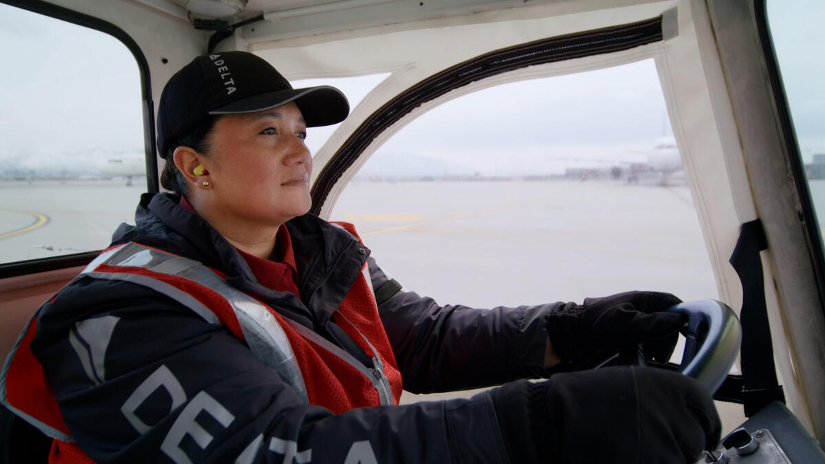 Delta Ramp Agent Sinai Pauni drives an electric bag tractor at Salt Lake City International Airport (SLC).