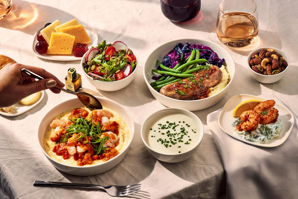 Delta One customers flying international on select flights may want to indulge in Chef Bailey’s creole shrimp with creamy grits and tomato gravy. Also available: Grilled bratwurst with braised red cabbage, herb mashed potatoes, green beans and a grain mustard demi-glace; cauliflower soup with a snipped-chives garnish; poached shrimp appetizer with cucumber yogurt sauce and lemon; and a side salad of mixed greens with radish, tomatoes and balsamic vinaigrette.