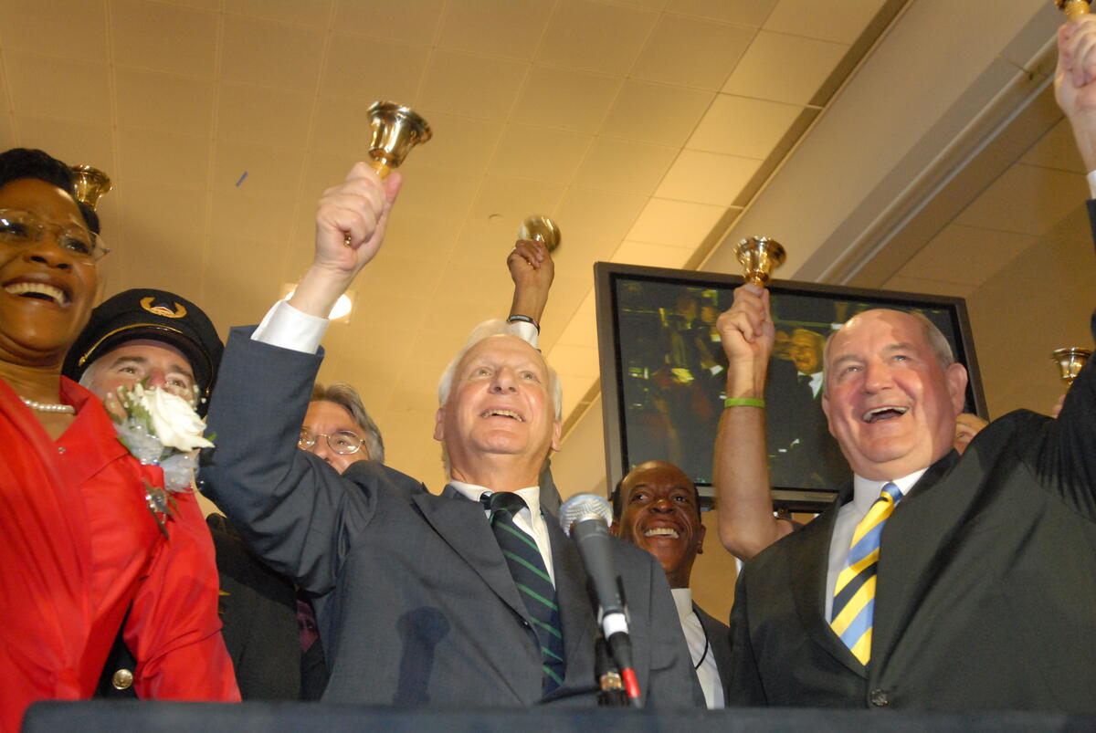 Former Delta CEO Jerry Grinstein rings a bell, signifying Delta's emergence from Chapter 11 bankruptcy.