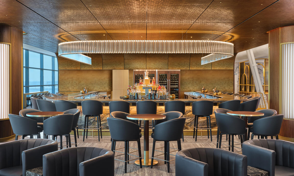 The premium bar at The Delta Lounge - JFK serves elevated takes on classic cocktails and features a standout Art Deco-inspired lighting fixture.