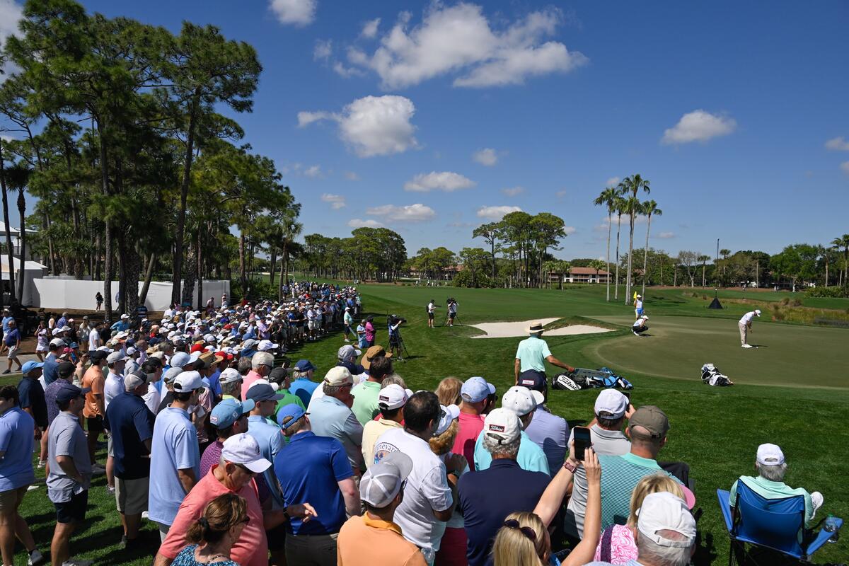 Fans surround a golf green while attending a PGA Tour event.