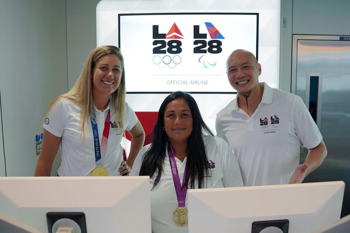 U.S. Olympians April Ross (left) and Brenda Villa (center), and U.S. Paralympian Jen Lee (right)&nbsp;pose for a photo at LAX near Delta's co-created LA28 logo on Sept. 29, 2022.